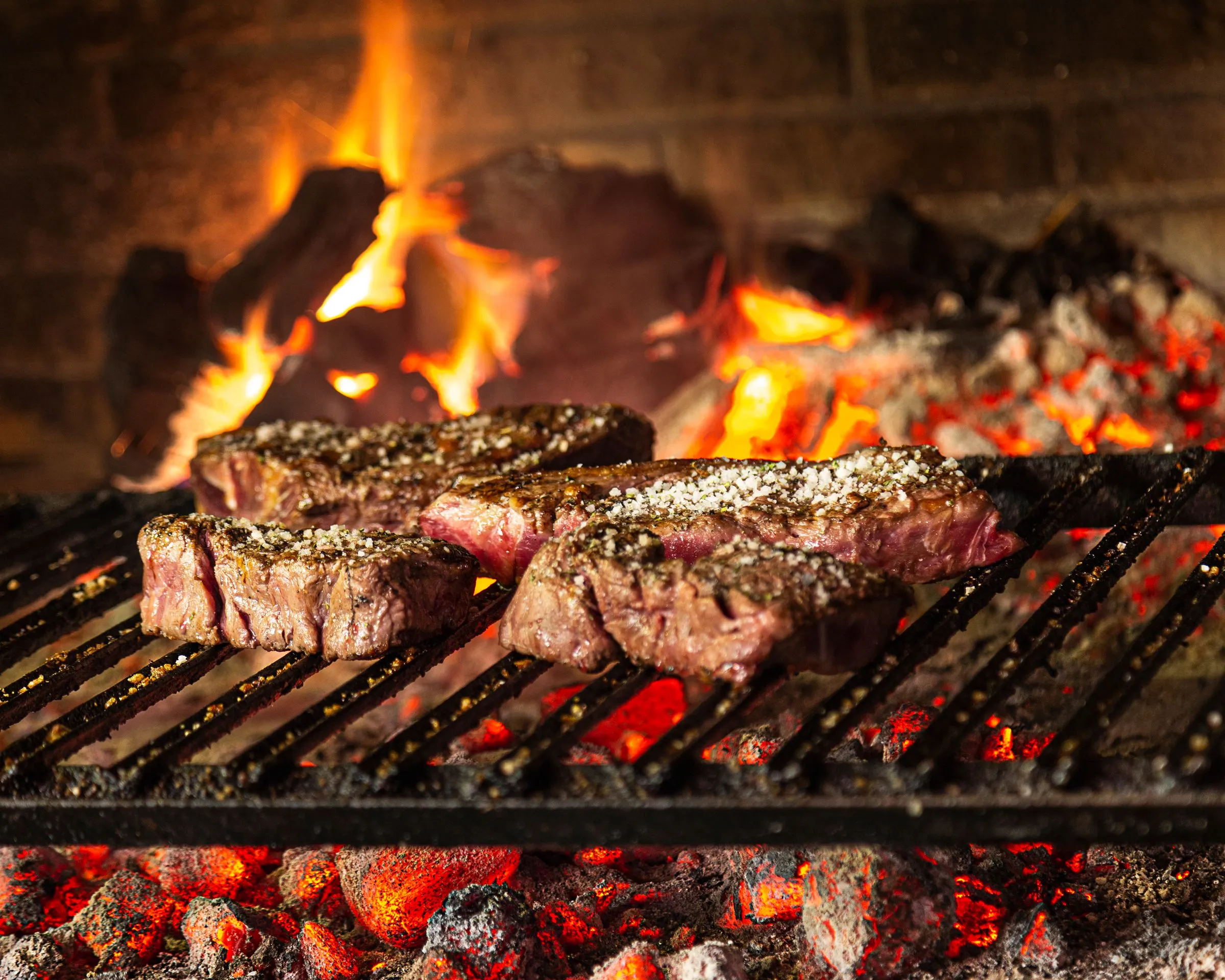 Txuletas de vaca vieja sobre la parrilla de leña de Asador Artebe, con la brasa viva